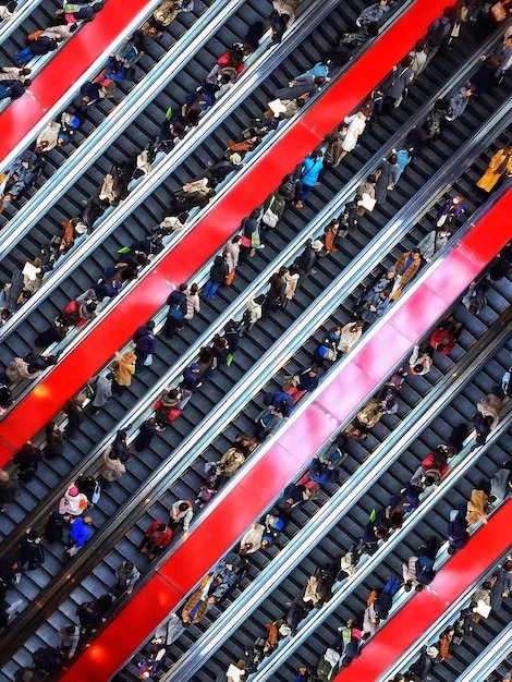 Fans exiting the Emirates Stadium after a match. A crowd of people are walking towards the Arsenal tube station, with red Arsenal scarves and jerseys visible.
