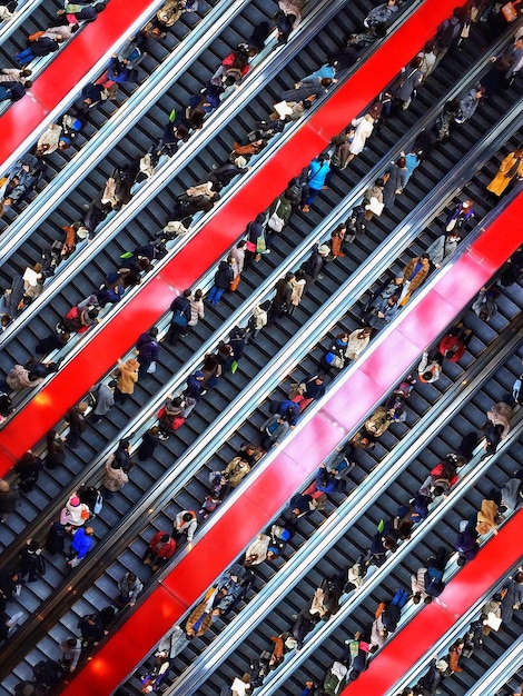 Fans exiting the Emirates Stadium after a match. A crowd of people are walking towards the Arsenal tube station, with red Arsenal scarves and jerseys visible.