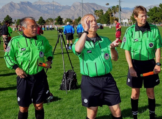 A wide shot of a team training session, with players wearing vests equipped with GPS trackers. The background shows a modern training facility, and the focus is on the technology being used to monitor player performance and fitness levels. The scene conveys a sense of innovation and data-driven preparation.